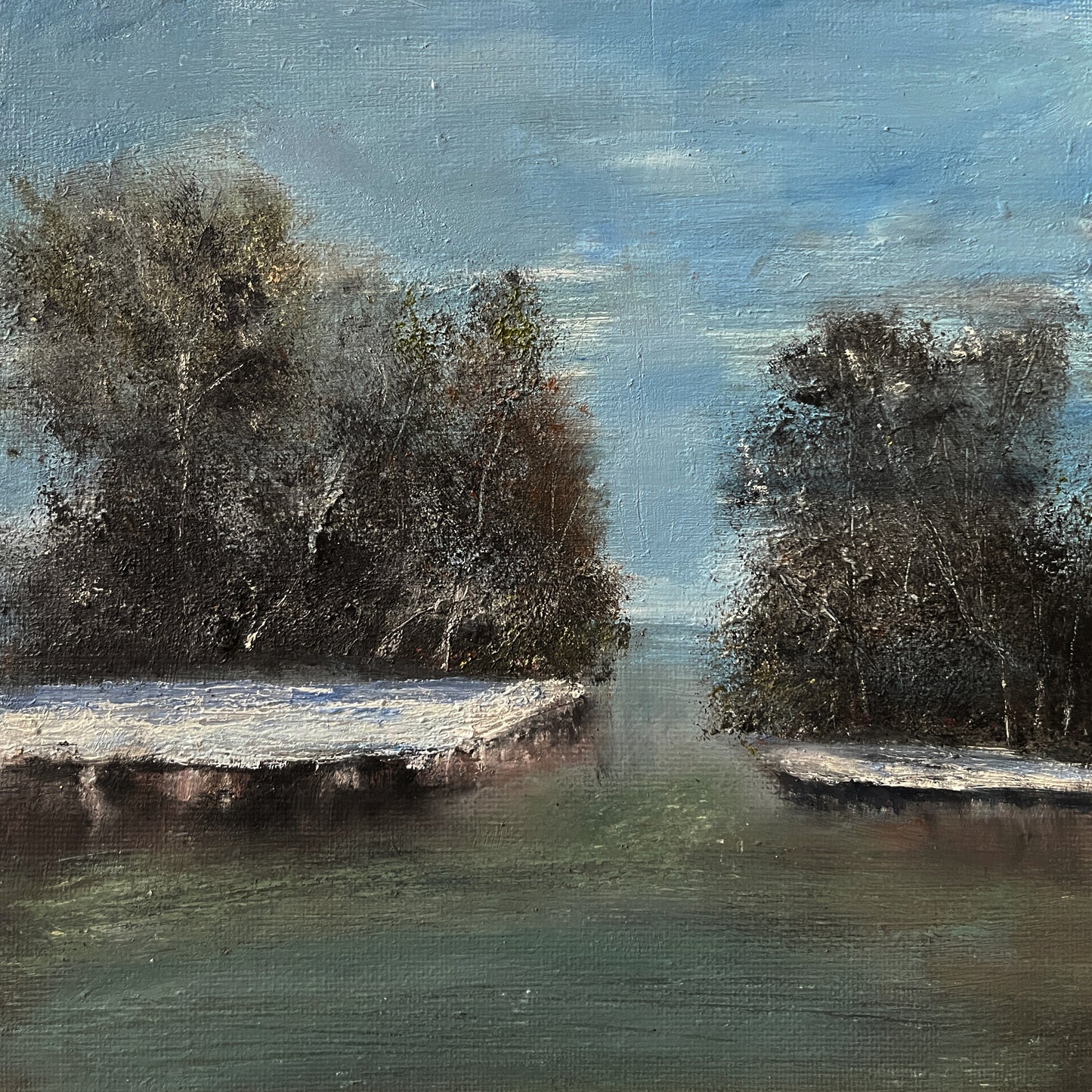 An impressionistic landscape painting of a calm river or inlet between two dark, snow-dusted tree islands under a blue sky, rendered with visible brush texture.