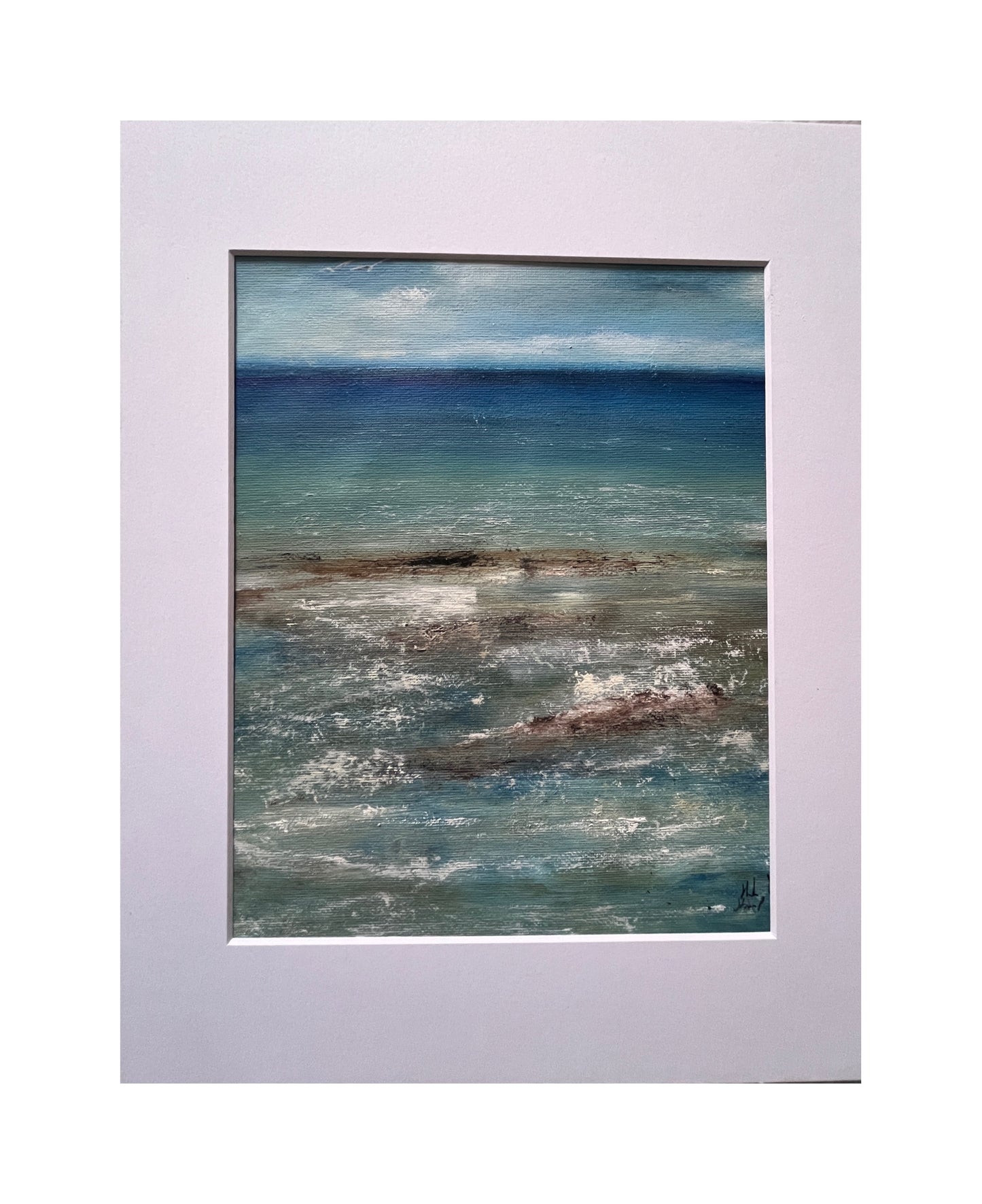 Framed artwork of a coastal scene with ocean and sky.