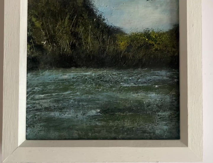 framed oil painting of river and trees and birds in a white wooden frame